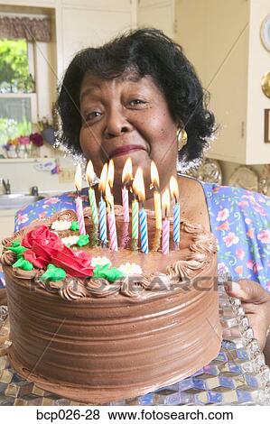 Stock Photo - Woman holding a chocolate birthday cake. Fotosearch
