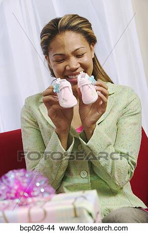 Woman holding baby shoes View Large Photo Image Picture - Woman holding baby shoes. Fotosearch