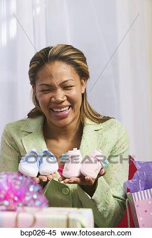 Woman holding baby shoes View Large Photo Image Stock Photography - Woman holding baby shoes. Fotosearch