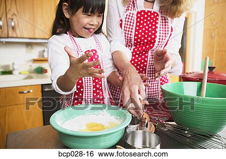 A female adult and child cooking together View Large Photo Image Stock Photograph - A female adult and child cooking together. Fotosearch