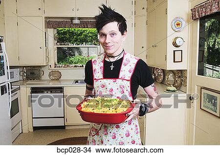 Man in kitchen holding a casserole View Large Photo Image Picture - Man in kitchen holding a casserole. Fotosearch