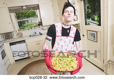 Man in kitchen holding a casserole View Large Photo Image Stock Image - Man in kitchen holding a casserole. Fotosearch