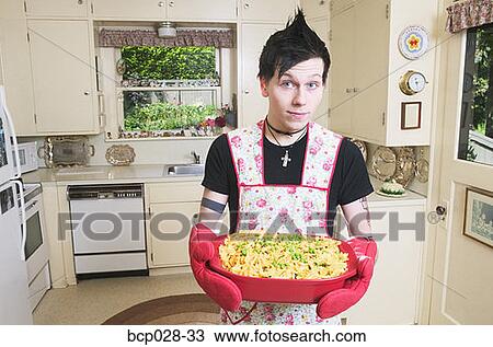 Man in kitchen holding a casserole View Large Photo Image Stock Image - Man in kitchen holding a casserole. Fotosearch