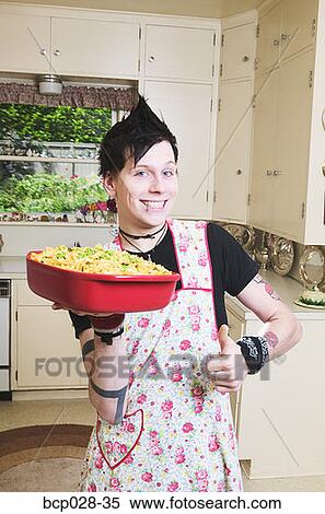Man in kitchen holding a casserole View Large Photo Image Stock Photography - Man in kitchen holding a casserole. Fotosearch