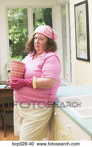 Unhappy woman about to wash dishes View Large Photo Image Stock Image - Unhappy woman about to wash dishes. Fotosearch