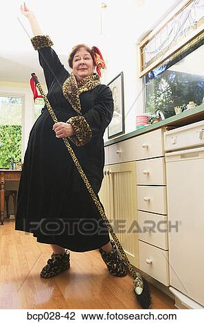 Woman dancing while sweeping View Large Photo Image Stock Image - Woman dancing while sweeping. Fotosearch