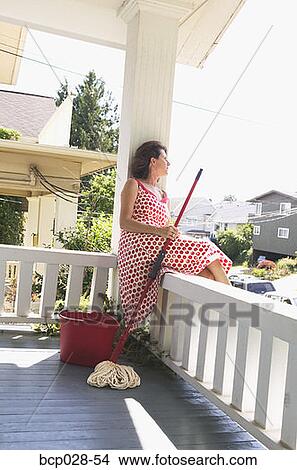 Picture - Woman taking a break from mopping. Fotosearch