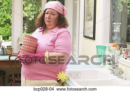 Woman unhappy about washing dishes View Large Photo Image Picture - Woman unhappy about washing dishes. Fotosearch