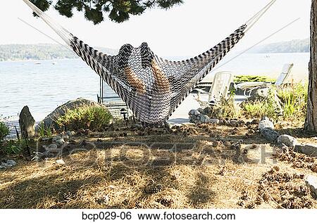 Boy relaxing in a hammock at the shore View Large Photo Image Stock Photograph - Boy relaxing in a hammock at the shore. Fotosearch