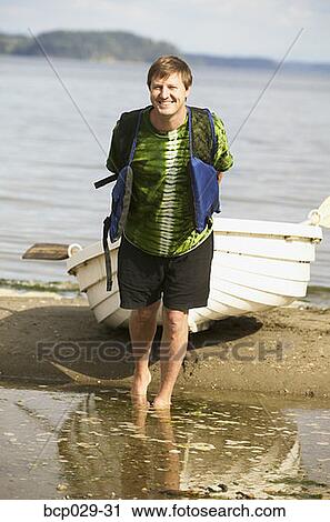 Man pulling a boat ashore View Large Photo Image Stock Image - Man pulling a boat ashore. Fotosearch