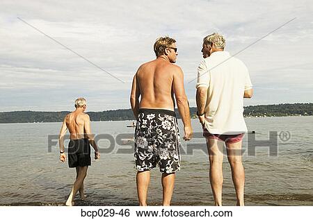 Men cooling off at the shore View Large Photo Image Stock Photograph - Men cooling off at the shore. Fotosearch