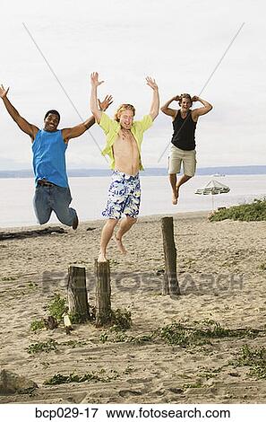 Stock Photo - Men leaping off tree stumps. Fotosearch