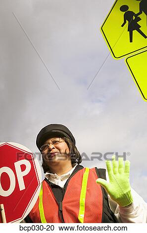 A female crossing guard at work View Large Photo Image Stock Image - A female crossing guard at work. Fotosearch