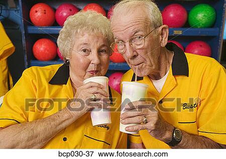 Stock Photo - Bowling couple enjoying beverages. Fotosearch