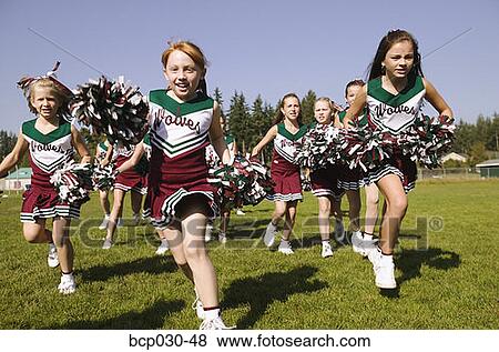 Cheerleaders running on an athletic field View Large Photo Image Stock Photo - Cheerleaders running on an athletic field. Fotosearch