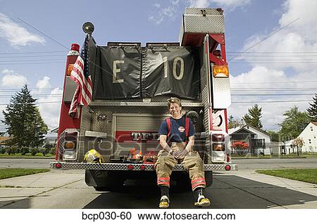 Female firefighter sitting on a fire truck View Large Photo Image Stock Image - Female firefighter sitting on a fire truck. Fotosearch