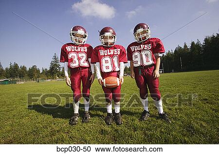 Stock Image - Group of three young football players. Fotosearch