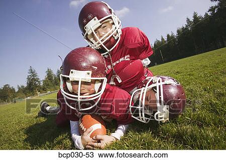 Three kids playing football View Large Photo Image Stock Image - Three kids playing football. Fotosearch