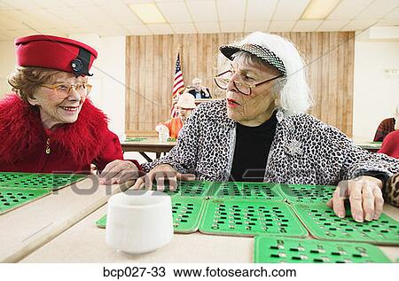 Stock Image - Pair of women playing bingo. Fotosearch