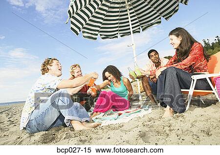 Stock Photography - People relaxing at a beach party. Fotosearch