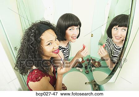 Women putting on makeup View Large Photo Image Stock Photo - Women putting on makeup. Fotosearch