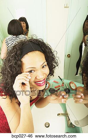 Stock Photograph - Women putting on makeup. Fotosearch