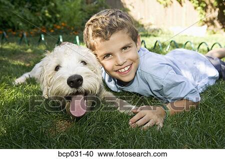 Boy and dog lying down together outdoors View Large Photo Image Stock Image - Boy and dog lying down together outdoors. Fotosearch