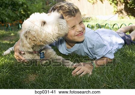 Boy and dog lying down together outdoors View Large Photo Image Stock Image - Boy and dog lying down together outdoors. Fotosearch