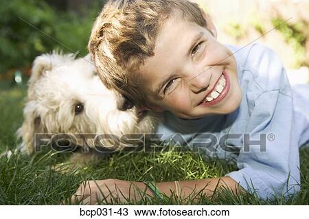 Boy and dog lying down together outdoors View Large Photo Image Stock Image - Boy and dog lying down together outdoors. Fotosearch