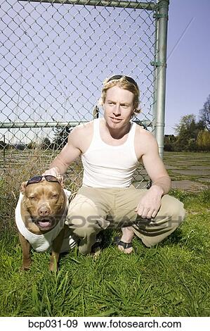 Stock Photo - Man outdoors with pet Pit Bull. Fotosearch