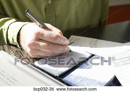 Stock Photography - Closeup of man writing out a check. Fotosearch