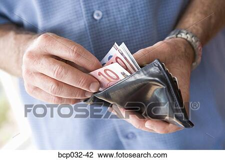 Stock Image - Man counting banknotes in wallet. Fotosearch