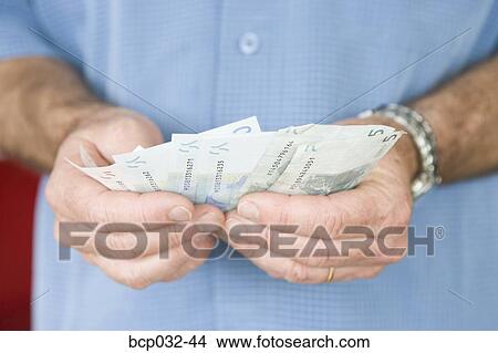 Man holding euro banknotes View Large Photo Image Picture - Man holding euro banknotes. Fotosearch