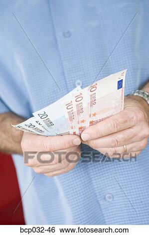 Man holding euro banknotes View Large Photo Image Stock Photograph - Man holding euro banknotes. Fotosearch