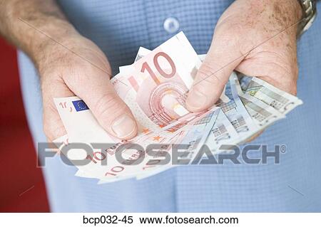 Man holding euro banknotes View Large Photo Image Stock Photography - Man holding euro banknotes. Fotosearch