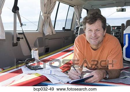 Man writing checks in his van View Large Photo Image Stock Photo - Man writing checks in his van. Fotosearch