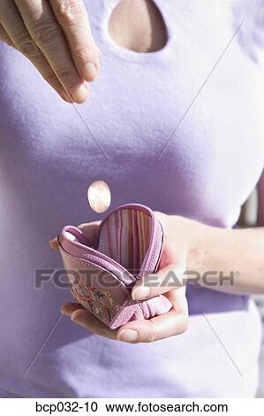 Woman dropping coin in change purse View Large Photo Image Stock Image - Woman dropping coin in change purse. Fotosearch