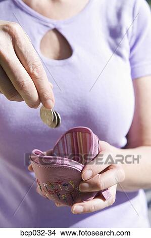 Woman dropping coins into change purse View Large Photo Image Picture - Woman dropping coins into change purse. Fotosearch