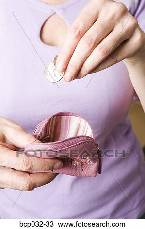 Woman dropping coins into change purse View Large Photo Image Stock Image - Woman dropping coins into change purse. Fotosearch