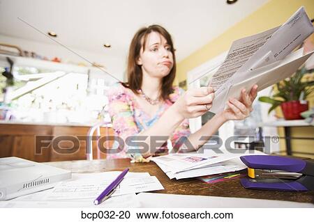 Woman looking at bills in mail View Large Photo Image Stock Image - Woman looking at bills in mail. Fotosearch
