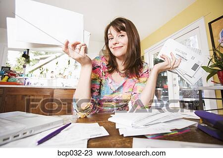 Woman looking at bills in mail View Large Photo Image Stock Image - Woman looking at bills in mail. Fotosearch