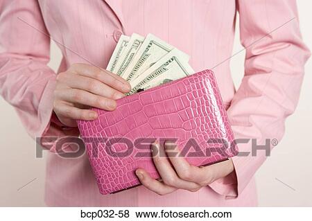 Woman removing American currency from purse View Large Photo Image Stock Photo - Woman removing American currency from purse. Fotosearch