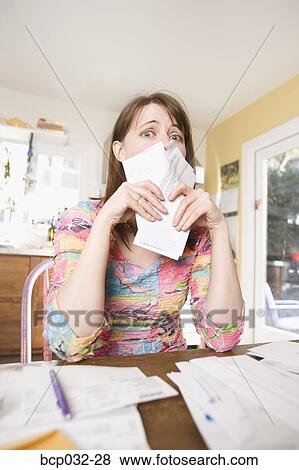 Woman sorting through bills at home View Large Photo Image Stock Photo - Woman sorting through bills at home. Fotosearch