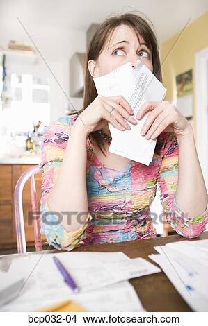 Worried woman holding bills View Large Photo Image Picture - Worried woman holding bills. Fotosearch
