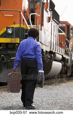 Boy walking beside train with baggage View Large Photo Image Stock Photo - Boy walking beside train with baggage. Fotosearch