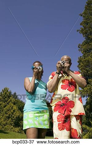 Stock Photo - Couple with cameras taking pictures. Fotosearch