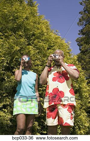 Couple with cameras taking pictures View Large Photo Image Stock Photograph - Couple with cameras taking pictures. Fotosearch