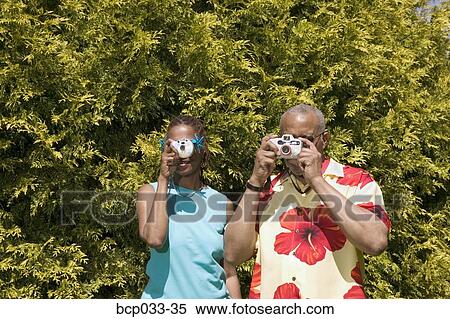 Couple with cameras taking pictures View Large Photo Image Stock Photography - Couple with cameras taking pictures. Fotosearch