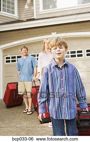 Stock Photograph - Family pulling luggage. Fotosearch