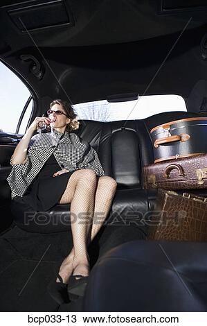 Stock Image - Woman and luggage in limousine. Fotosearch